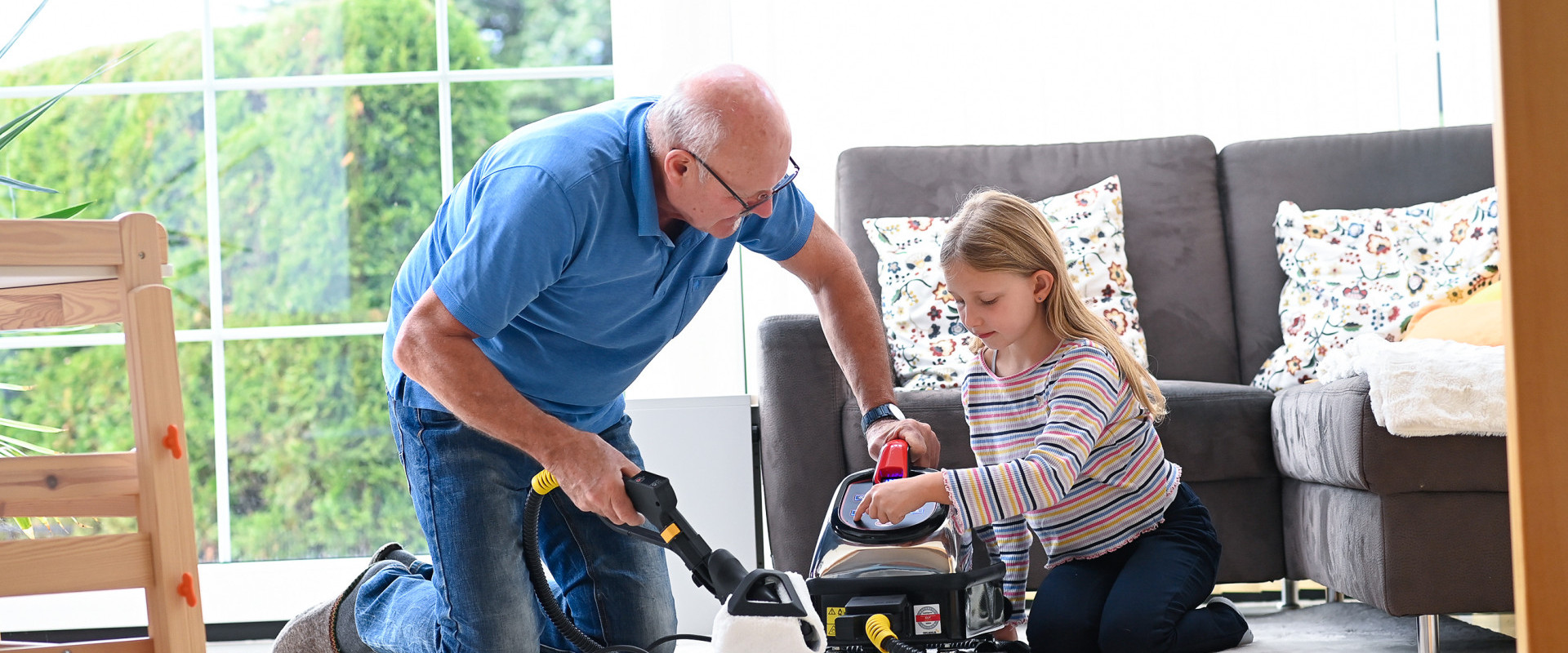A grandfather explains the simple operation of the Thermostar dry steam cleaner to his granddaughter
